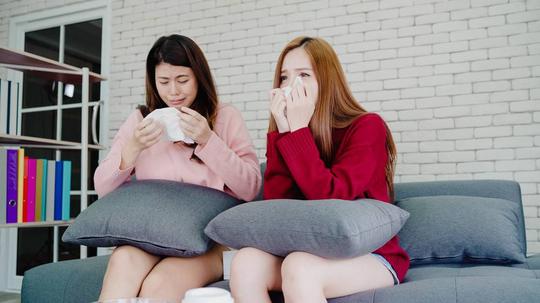 亚洲女同性恋夫妇在家中起居室看电视时哭泣_4015332