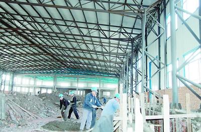 木制品创业服务中心的1号厂房内工人正在进行地面施工臧世家摄