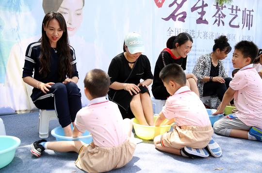 小朋友很认真的给妈妈洗脚.