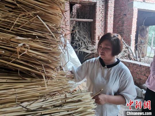 图为张蓉蓉对麦秸进行选材分类。郝学娟摄