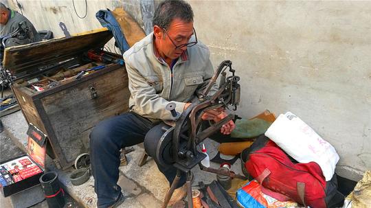 实拍农村街头掌鞋修拉锁的人，寒风中等候顾客上门