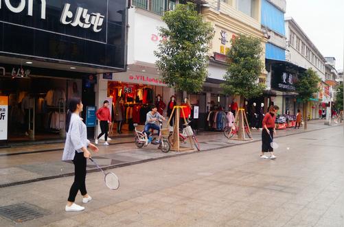 深圳大年初一商业街服装店门前，生意淡年轻女员工们在打羽毛球