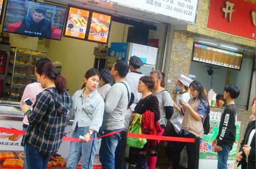 深圳某面包店美女员工站台销售生意好，顾客排长长队伍等候购买