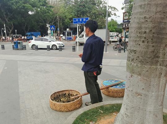 农村的兄弟挑了一担货在城市街头卖，生意惨淡，几乎没人买