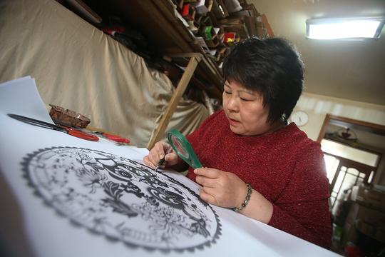 手持剪刀翻转7年天津53岁单亲妈妈靠剪纸谋生供女儿读研