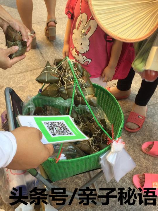 一对夫妻在幼儿园门口卖粽子，生意火热，蛋黄肉粽4元一个