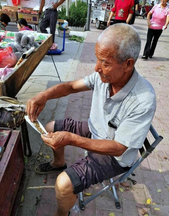 76岁老人赶集卖百货，一天挣不到30元钱，省吃俭用抽旱烟