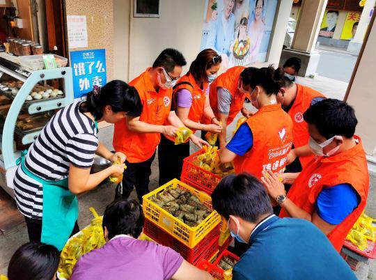 广东侨乡台山志愿者与长者分粽同味品端午