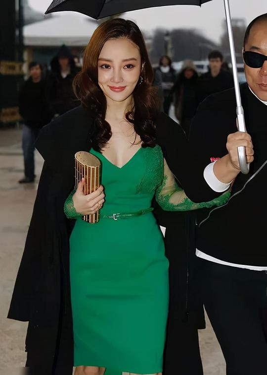 李小璐穿绿色蕾丝裙配黑色大衣，单手撑伞优雅霸气，妥妥的女王范